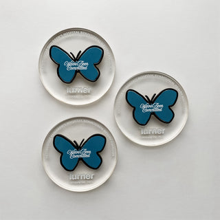 custom clear acrylic circular mementos with blue butterfly detail 