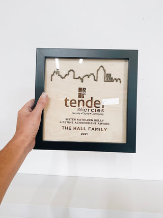 framed award with engraved wood and a floating cincinnati skyline