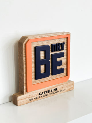 oak hardwood award with engraved base and raised orange and blue company logo 