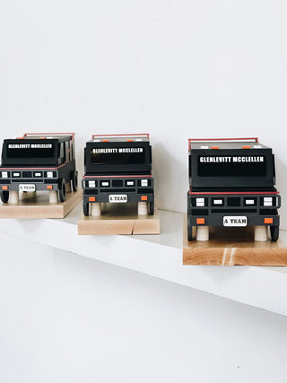 3D signature award in the shape of a van on a wooden platform, painted wood details