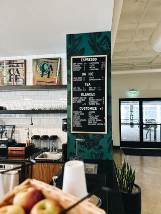 custom wall menu for a cafe with white text, black background and wood border