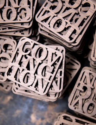 custom walnut coasters with cutout design of city name 