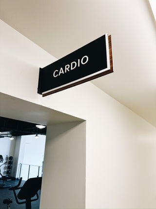 wayfinding sign cardio black acrylic with layered white acrylic letters and wood trim