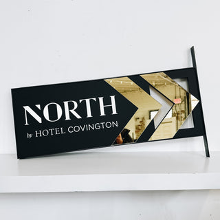 wayfinding sign black and gold acrylic, business name in white text