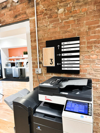 black acrylic directory with floor number displayed on wood piece and rows of white acrylic with company names
