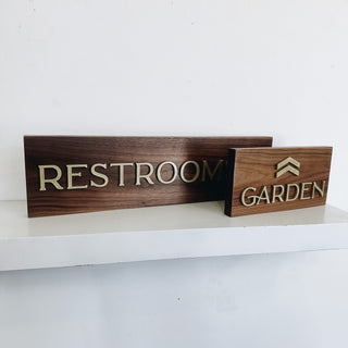 wooden wayfinding restroom and garden signs with raised gold text