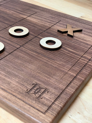 custom wood tic tac toe game with wood pieces and engraved company logo in corner