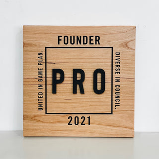 maple wooden award with black paint filled engraved lettering and raised lettering in the center