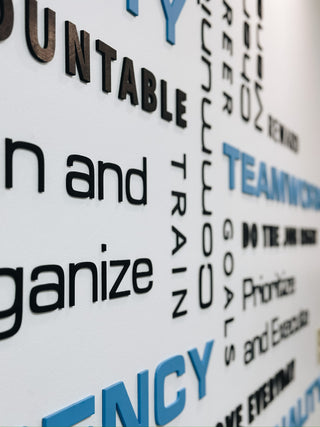 an up close view of the large scale installation of black and blue words on a wall in different sizes and directions