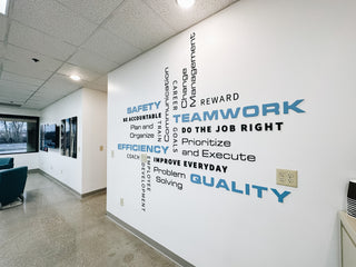 large scale installation of blue and black words places on a wall in different directions and sizes 