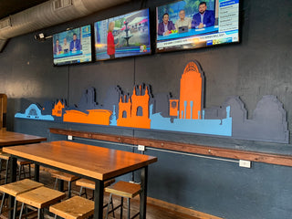 large scale installation of the cincinnati skyline in orange and blue 
