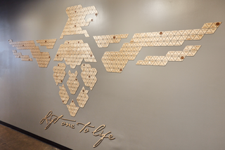 large scale installation of a company logo made of little triangles arranged together and script at the bottom