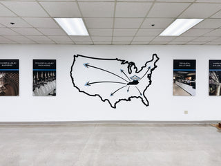 large scale installation of a black outline of the usa with a black kentucky shape inside with arrows pointing out of it 
