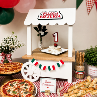 Children's birthday party setup with pizza, balloons, and a small pizzeria stand.